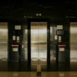 Sleek elevator lobby with stainless steel doors, reflecting modern architecture.
